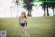 A woman standing in a grassy field next to the ocean.