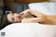 A woman laying on top of a bed in a black lingerie.