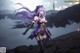 A woman with long purple hair standing on a rock by the water.