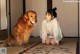 A woman sitting on the floor next to a dog.