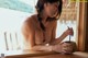 A woman sitting at a table with a cup of coffee.