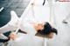 A woman laying on a bench in a gym.