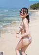 A woman in a bikini standing on a beach.